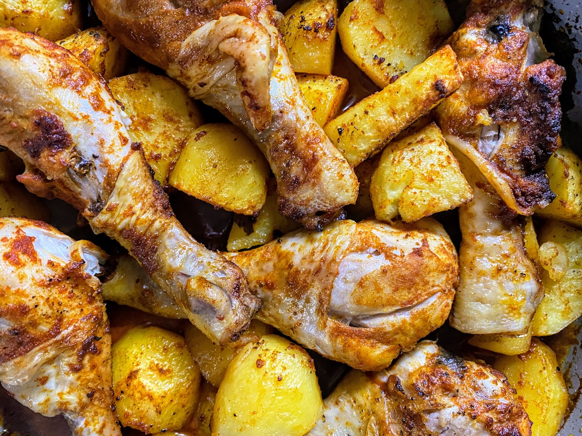 Sheet-pan chicken thighs roasted golden with chunks of potato, straight out of the oven